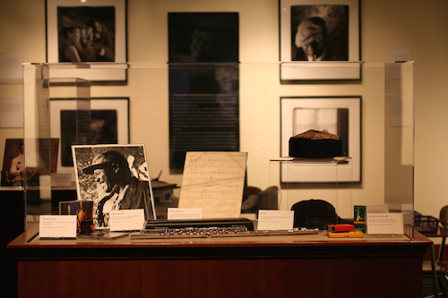 exhibit on wooden table in glass case of photos and writing on paper