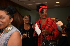 A woman in a black dress and a woman in a red flannel dress walk through a Taste of Black Little Rock